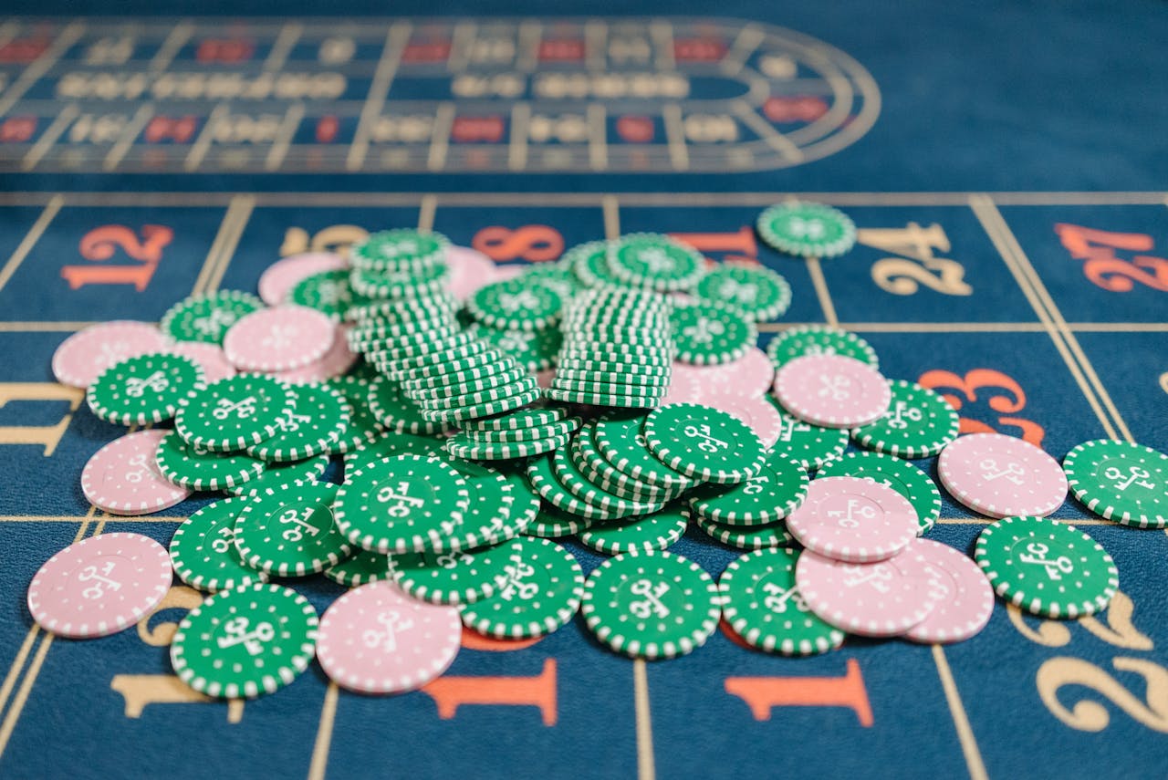 Close-up of a roulette table with a pile of green and pink poker chips.